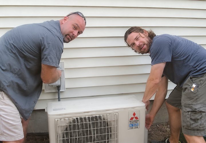 HVAC technicians installing a mini-split unit